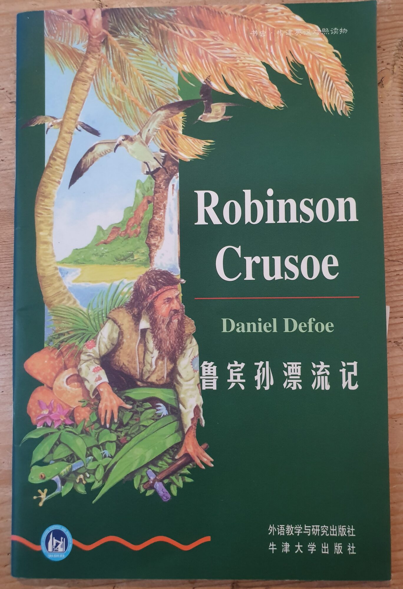 Titelseite von Robinson Crusoe in der chinesischen Bücherwurm-Reihe. Darauf ist eine farbige Illustration von Crusoe auf der Insel zu sehen, sowie der englische und chinesische Titel.